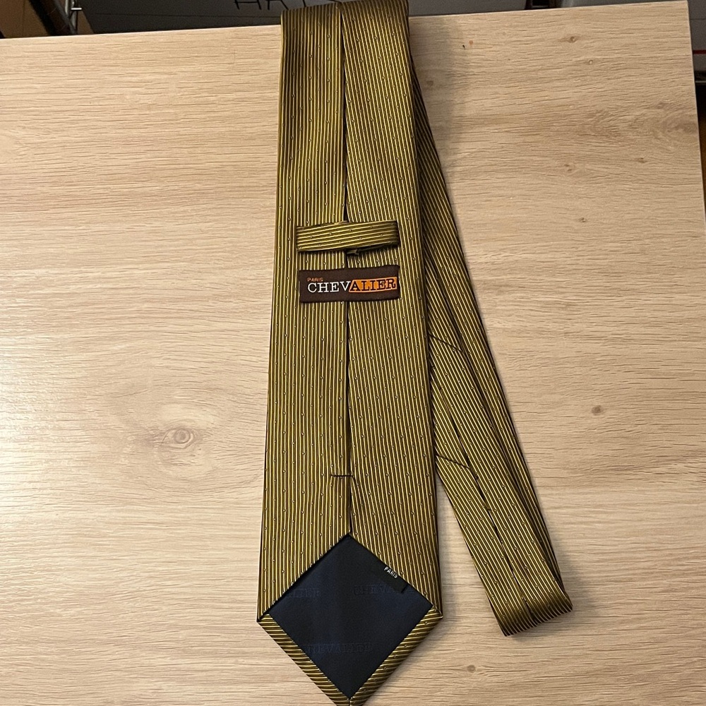 Chevalier Paris necktie with gold vertical stripes and small blue polka dots.